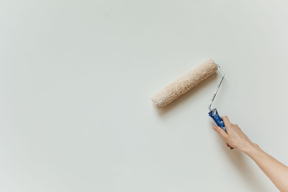 Hand painting a wall with a roller during renovation